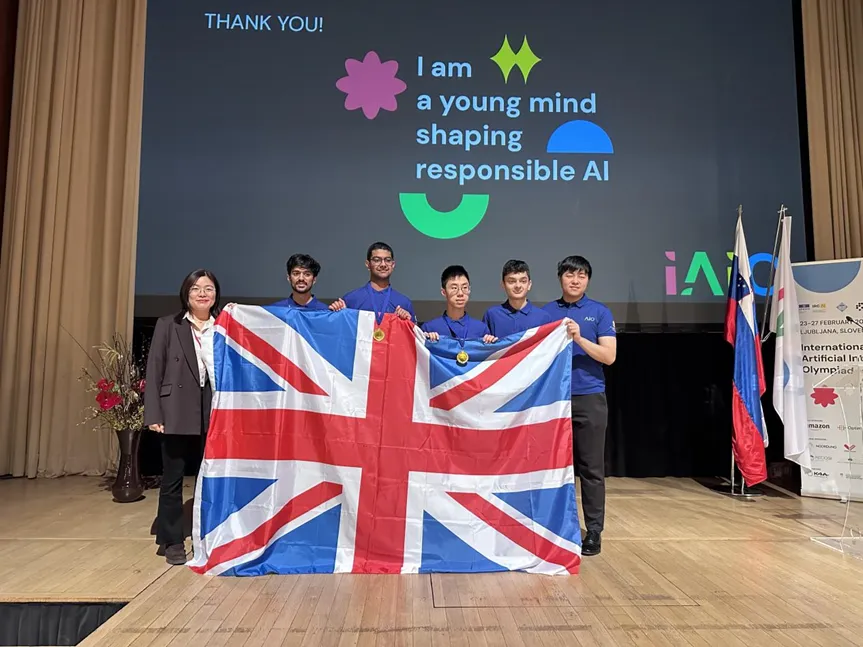 Team UK holding the Union flag on stage at the IAIO 2026 closing ceremony